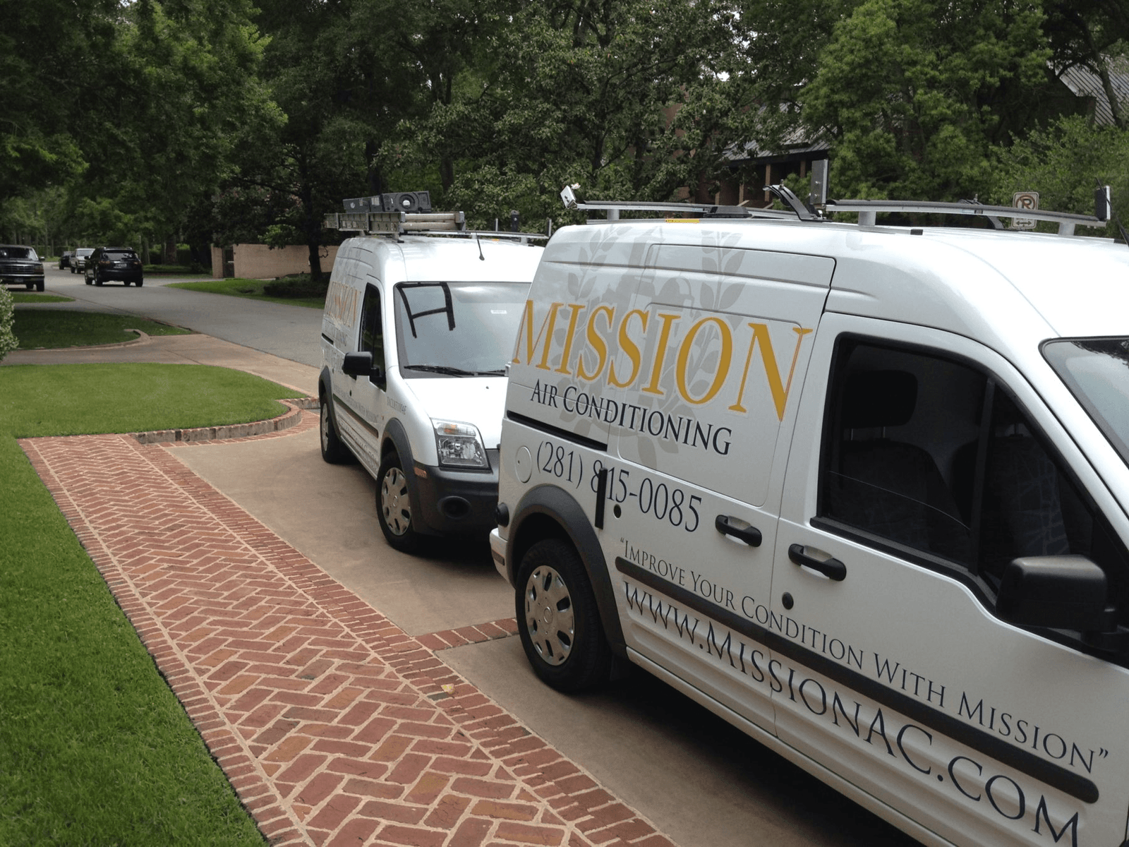 Branded Mission service vans at a Houston home